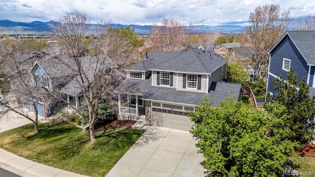 traditional-style home featuring a garage, a mountain view, driveway, and a front yard