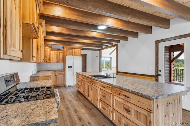 573 Beasley Blvd, Cotopaxi, CO 81223 - kitchen with white fridge with ice dispenser, stainless steel range with gas stovetop, beamed ceiling, plenty of natural light, and light wood finished floors