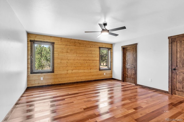 573 Beasley Blvd, Cotopaxi, CO 81223 - unfurnished bedroom with multiple windows, wood finished floors, wooden walls, and ceiling fan