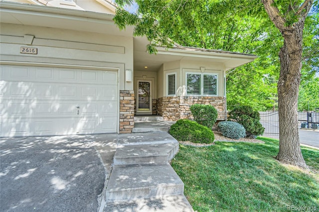 entrance to property with a garage and a lawn