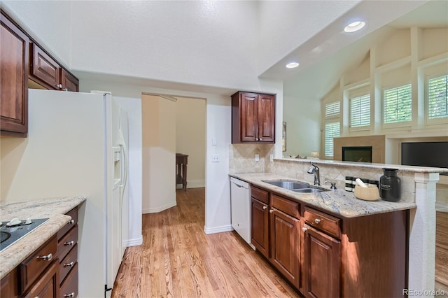 kitchen with sink, backsplash, lofted ceiling, white appliances, and light wood-type flooring