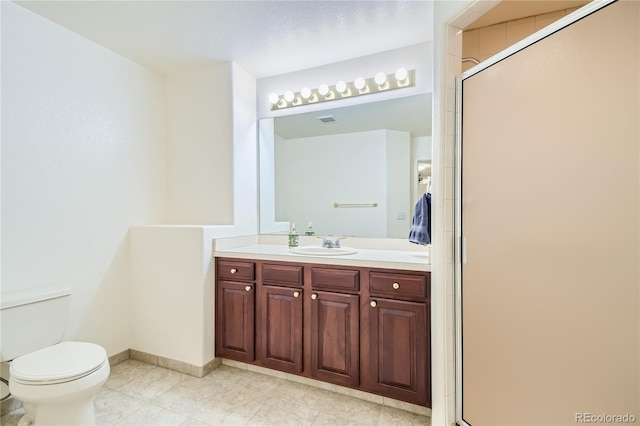 bathroom with vanity, a shower with shower door, and toilet