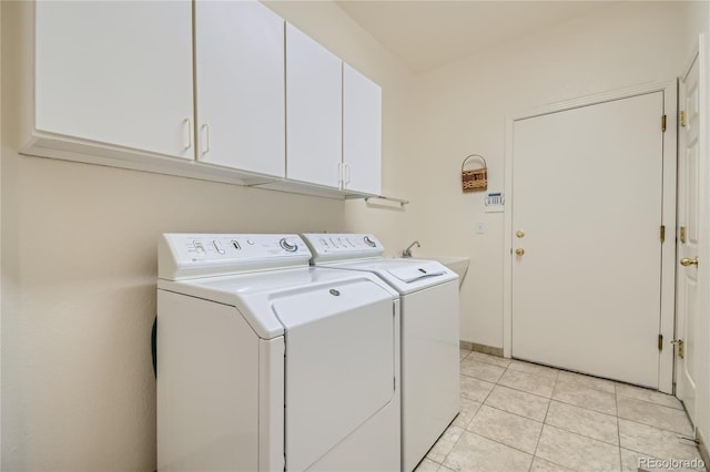 washroom with washing machine and clothes dryer, sink, light tile patterned floors, and cabinets