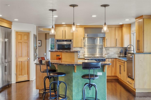 kitchen with light brown cabinetry, appliances with stainless steel finishes, and a kitchen island