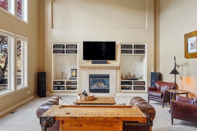 living room featuring a towering ceiling, light colored carpet, and plenty of natural light