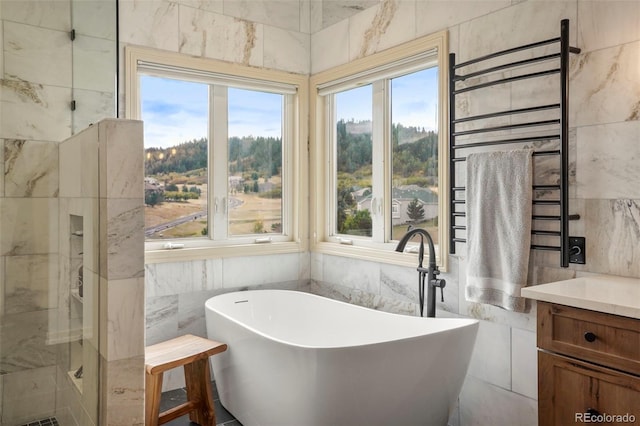 bathroom with vanity, tile walls, and plus walk in shower