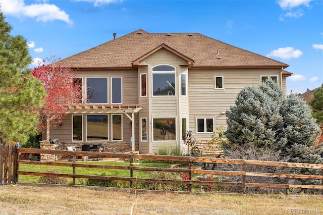 back of house with a lawn and a pergola