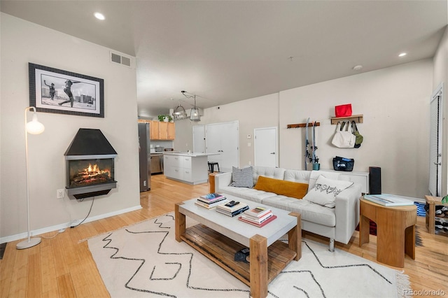 3225 Blake St Unit 4, Denver, CO 80205 - living room with light wood-style floors, a warm lit fireplace, and recessed lighting