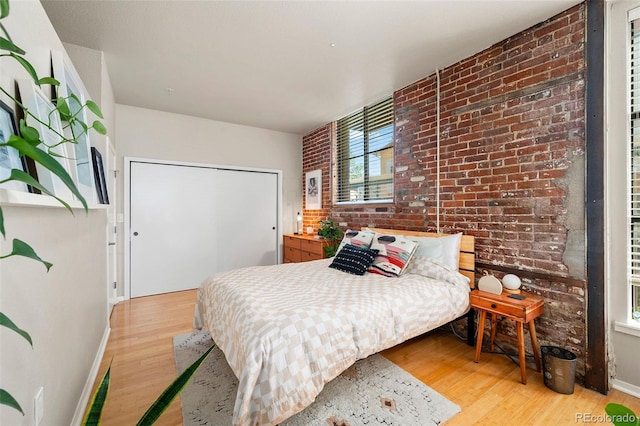 3225 Blake St Unit 4, Denver, CO 80205 - bedroom with light wood-style floors, a closet, and brick wall