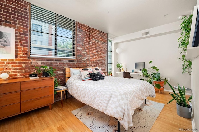 3225 Blake St Unit 4, Denver, CO 80205 - bedroom featuring light wood-style floors and brick wall