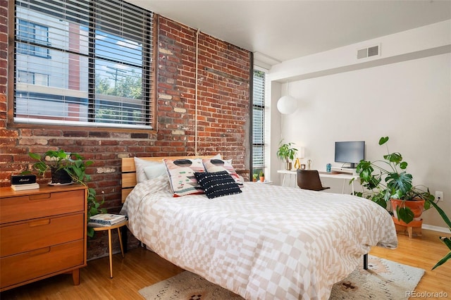 3225 Blake St Unit 4, Denver, CO 80205 - bedroom featuring wood finished floors and brick wall