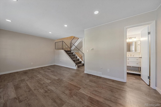 1827 Quail St Unit 3, Lakewood, CO 80215 - unfurnished living room featuring stairway, wood finished floors, baseboards, recessed lighting, and a sink