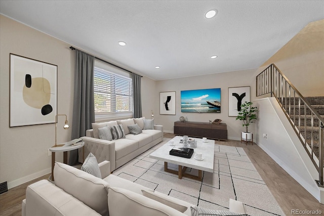 living room featuring a textured ceiling and light hardwood / wood-style floors