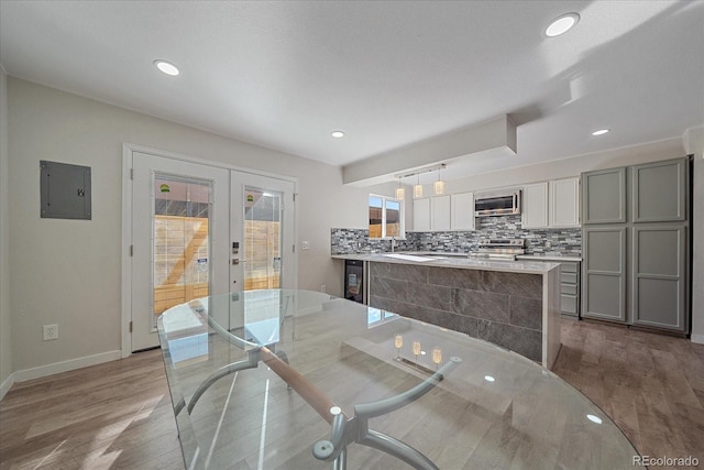 dining space with french doors, light wood-type flooring, sink, electric panel, and wine cooler