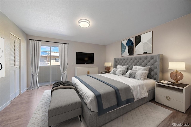 bedroom with a textured ceiling and light hardwood / wood-style flooring