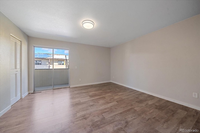 spare room with wood-type flooring and a textured ceiling