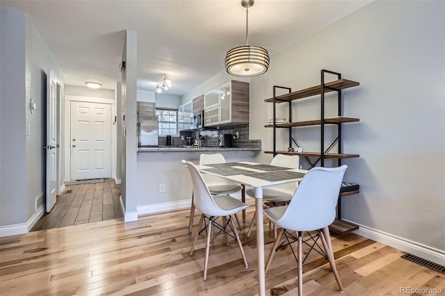 1818 S Quebec Way Unit 11-8, Denver, CO 80231 - dining room featuring baseboards, visible vents, and wood finished floors