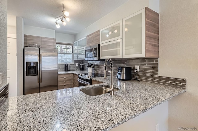 1818 S Quebec Way Unit 11-8, Denver, CO 80231 - kitchen with light stone countertops, appliances with stainless steel finishes, decorative backsplash, and a sink