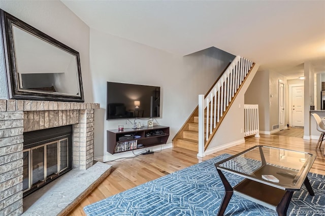1818 S Quebec Way Unit 11-8, Denver, CO 80231 - living area featuring a brick fireplace, baseboards, wood finished floors, and stairway