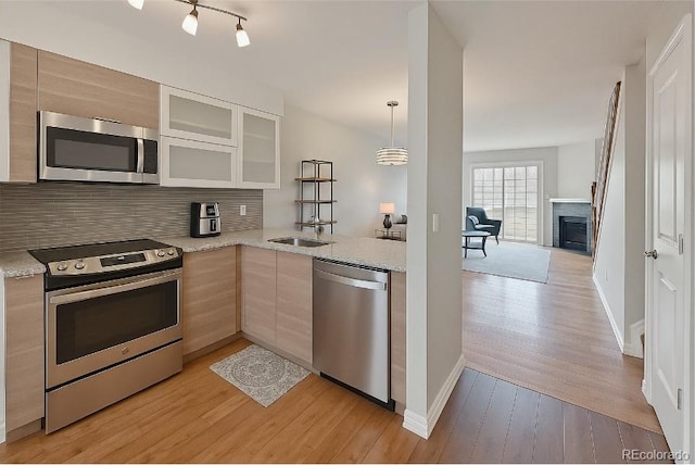 1818 S Quebec Way Unit 11-8, Denver, CO 80231 - kitchen with backsplash, stainless steel appliances, glass insert cabinets, and light wood-style flooring