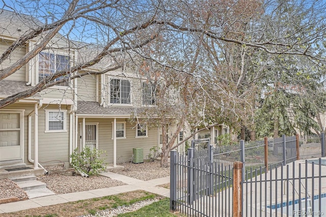 1818 S Quebec Way Unit 11-8, Denver, CO 80231 - view of front of property with central air condition unit, a fenced front yard, and roof with shingles