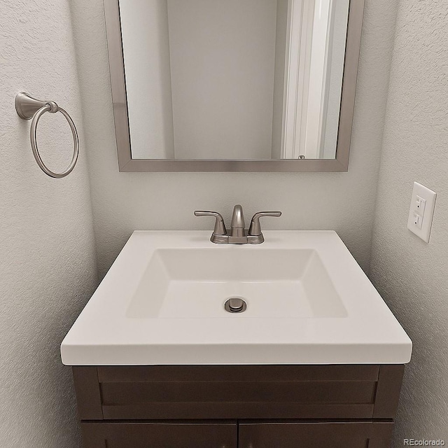 1818 S Quebec Way Unit 11-8, Denver, CO 80231 - bathroom featuring vanity and a textured wall