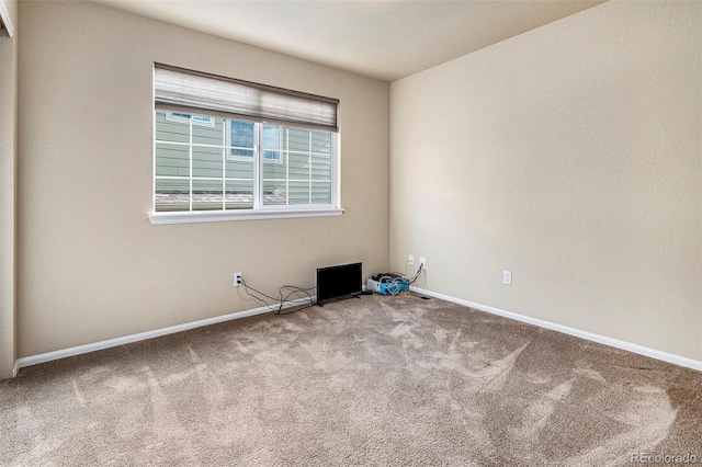 empty room featuring carpet and baseboards