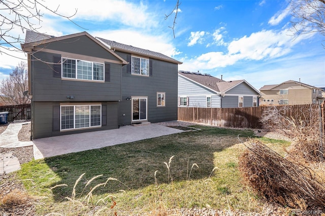 rear view of house featuring a fenced backyard, a lawn, and a patio