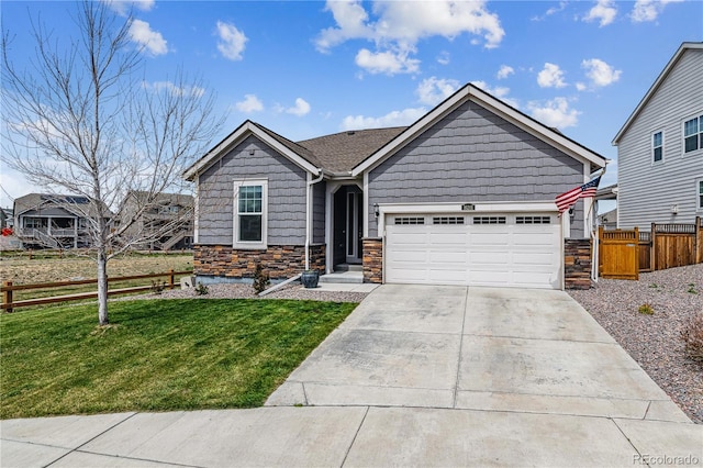 view of front facade with stone siding, a garage, fence, concrete driveway, and a front lawn