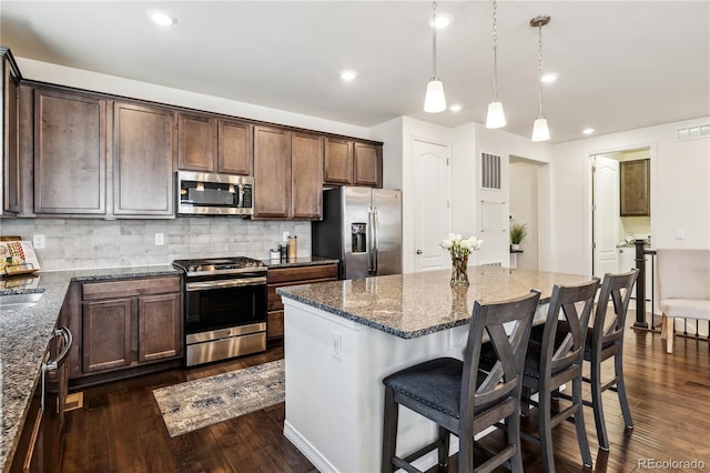 kitchen featuring visible vents, dark stone countertops, appliances with stainless steel finishes, and dark wood-style floors