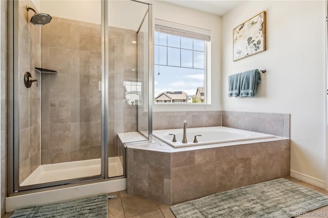 bathroom with a stall shower, a bath, and tile patterned floors