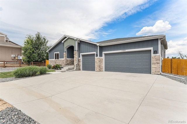 7293 Xenophon Ct, Arvada, CO 80004 - view of front of house featuring stone siding, board and batten siding, an attached garage, and driveway