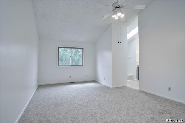 additional living space featuring vaulted ceiling, light colored carpet, a textured ceiling, and ceiling fan