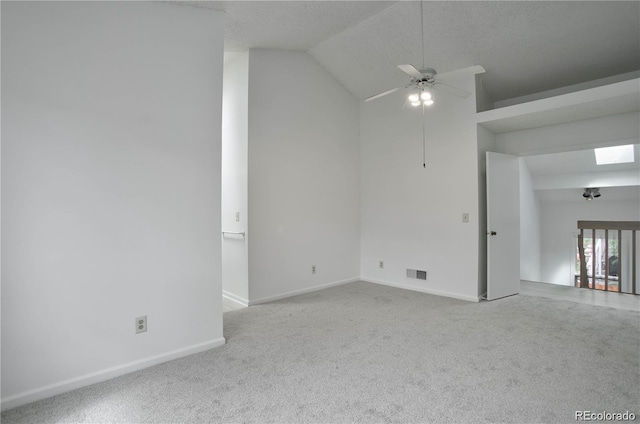 carpeted empty room with vaulted ceiling, a textured ceiling, and ceiling fan