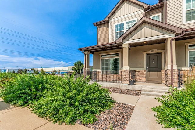 3805 N Himalaya Rd Unit 1, Denver, CO 80249 - doorway to property featuring board and batten siding, covered porch, and stone siding