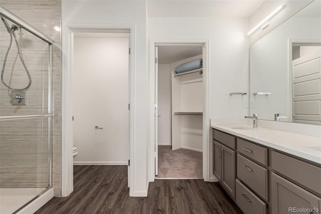 3805 N Himalaya Rd Unit 1, Denver, CO 80249 - bathroom with wood finished floors, a stall shower, double vanity, and a walk in closet