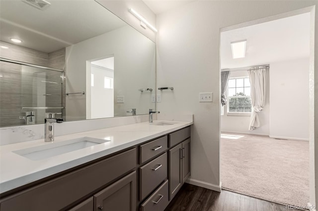 3805 N Himalaya Rd Unit 1, Denver, CO 80249 - full bath with double vanity, an enclosed shower, and wood finished floors