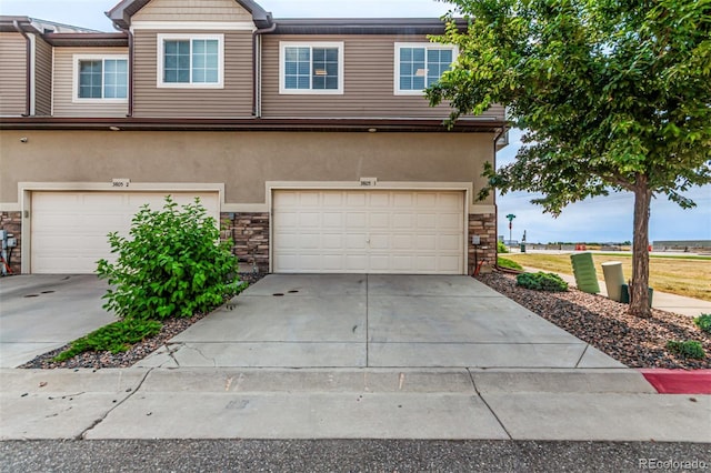 3805 N Himalaya Rd Unit 1, Denver, CO 80249 - view of front of property featuring stone siding, a garage, and driveway