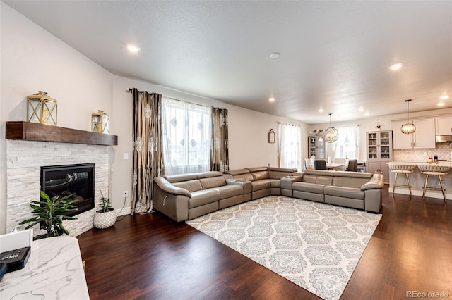 3722 Sandy Vista Trl, Castle Rock, CO 80104 - living room with healthy amount of natural light, dark wood-style floors, recessed lighting, and a stone fireplace