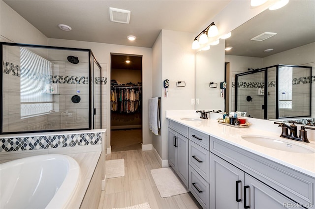 3722 Sandy Vista Trl, Castle Rock, CO 80104 - full bathroom with a stall shower, double vanity, a bath, a spacious closet, and baseboards