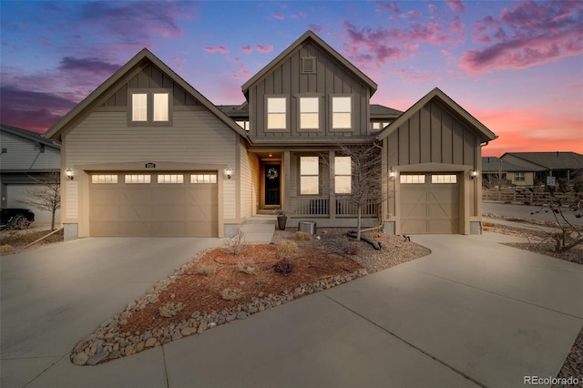 view of front facade with a garage, concrete driveway, board and batten siding, and covered porch