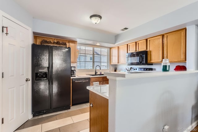 8199 Welby Rd Unit 3102, Denver, CO 80229 - kitchen featuring black appliances, light countertops, light tile patterned flooring, a peninsula, and brown cabinets