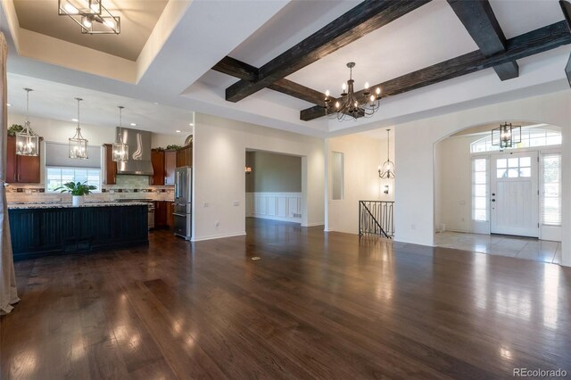 24733 E Park Crescent Dr, Aurora, CO 80016 - unfurnished living room featuring a chandelier, arched walkways, dark wood finished floors, coffered ceiling, and beamed ceiling