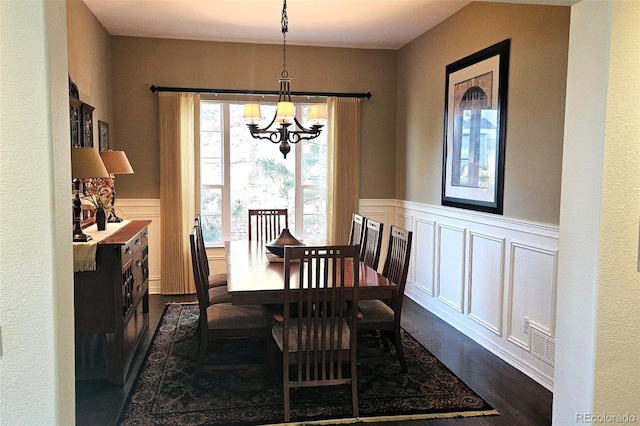 24733 E Park Crescent Dr, Aurora, CO 80016 - dining room with dark wood-style flooring, a chandelier, wainscoting, and a decorative wall