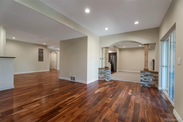 24733 E Park Crescent Dr, Aurora, CO 80016 - unfurnished living room with decorative columns, arched walkways, wood finished floors, and recessed lighting