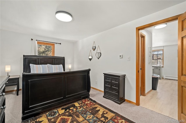 carpeted bedroom with a baseboard heating unit and multiple windows