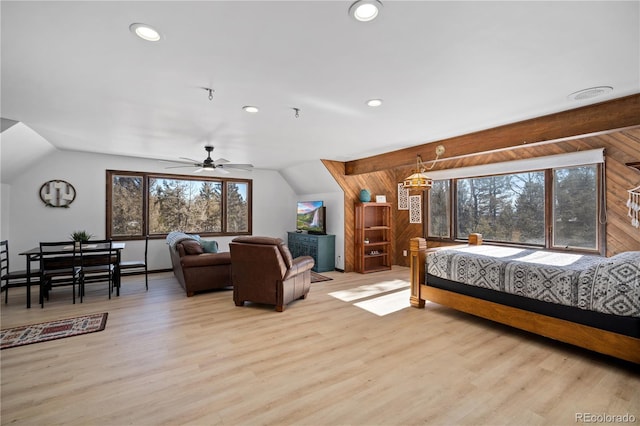 bedroom featuring ceiling fan, light hardwood / wood-style floors, vaulted ceiling, and multiple windows