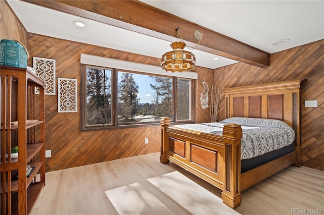 bedroom with beam ceiling and light hardwood / wood-style floors