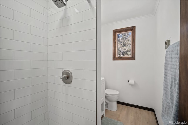 bathroom with toilet, a tile shower, ornamental molding, and hardwood / wood-style floors