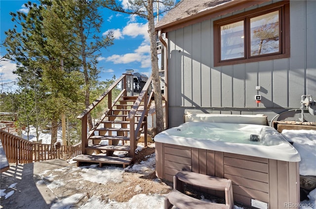 view of snow covered exterior with a hot tub